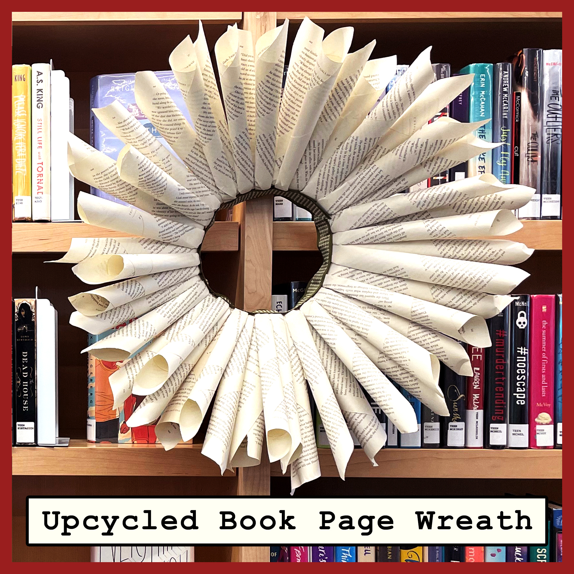 a wreath made of book pages rolled into cone shapes against a background of bookshelves