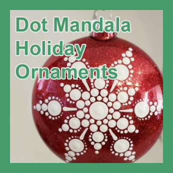 A red glass globe ornament decorated with a white snowflake made of painted dots