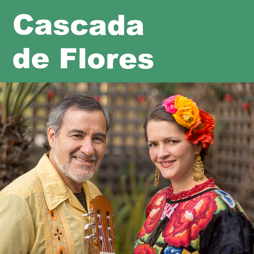 A man holding a guitar and a woman with flowers in her hair smile at the viewer. Caption: Cascada de Flores