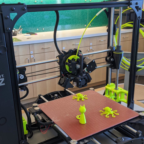 A Lulzbot TAZ 3D printer with fabricated figurines