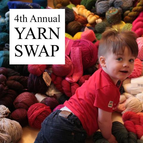 mischievous toddler crawling toward a huge pile of yarn looks over his shoulder at the viewer