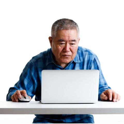 Older man studying information on his laptop