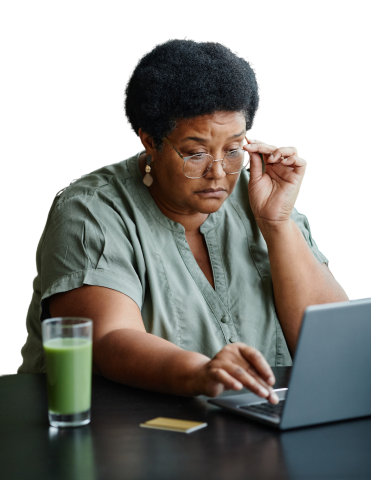 Woman adjusting her glasses, studying information on laptop