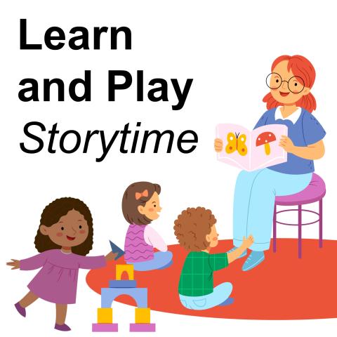 adult reads a book to two children while a third child plays with building blocks