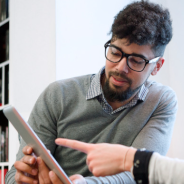 A tutor shows a learner how to use a tablet